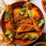 A bowl of arbi sabji with rice and papad.