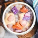 A bowl filled buber cha cha containing a variety of tapioca jellies, steamed root vegetables, and coconut porridge.