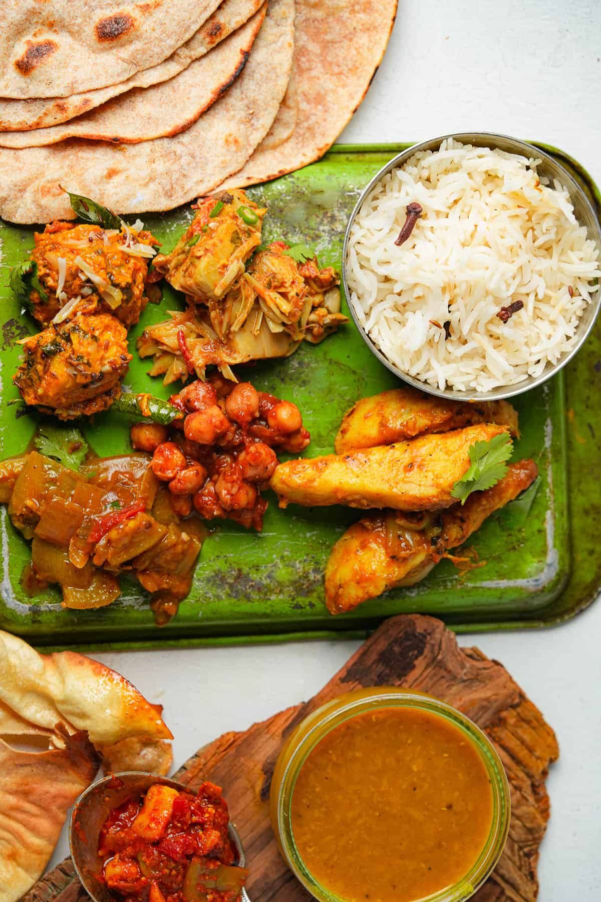 A tray with a variety of Indian food on it.