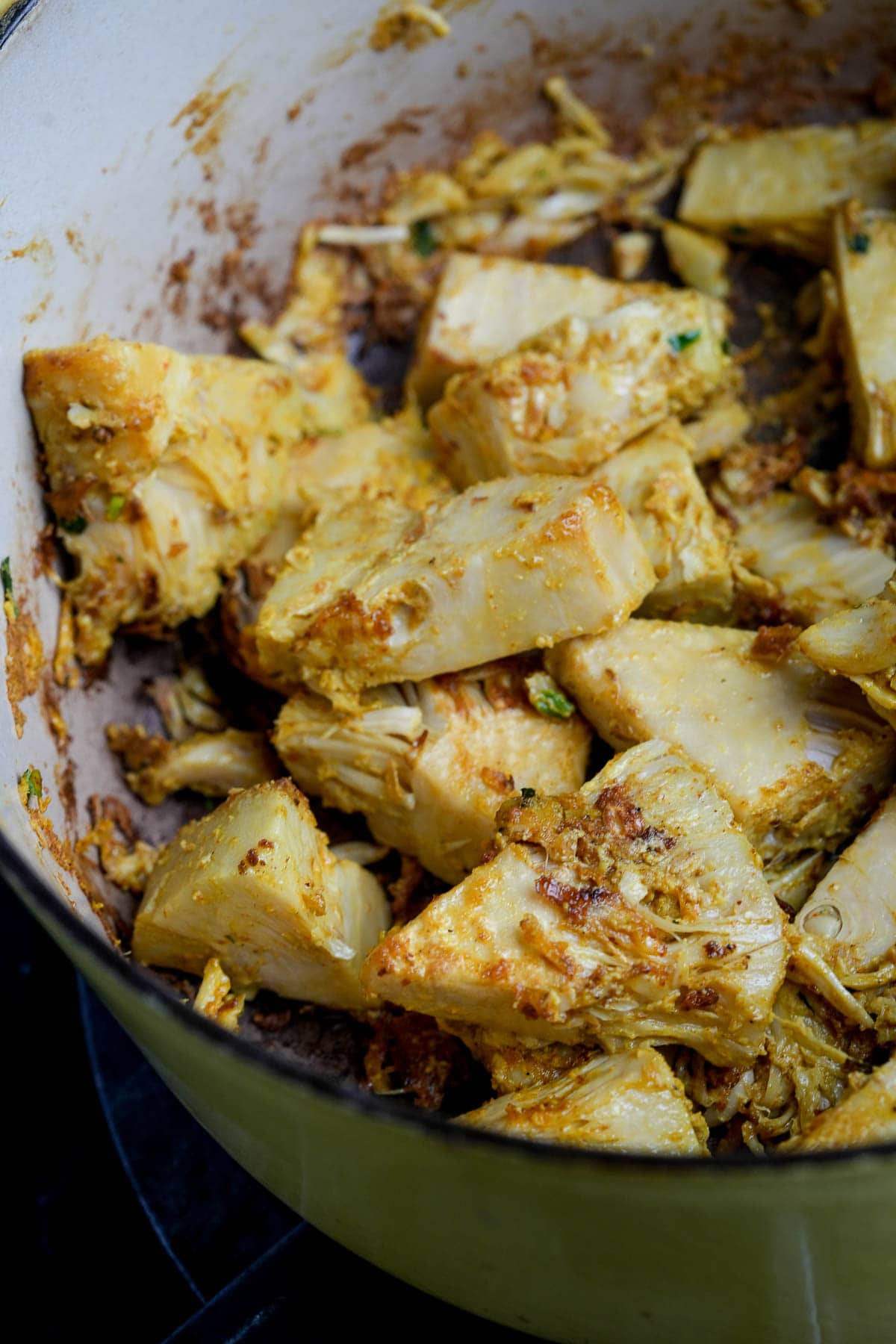 A pan full of fried jackfruit on a stove top.