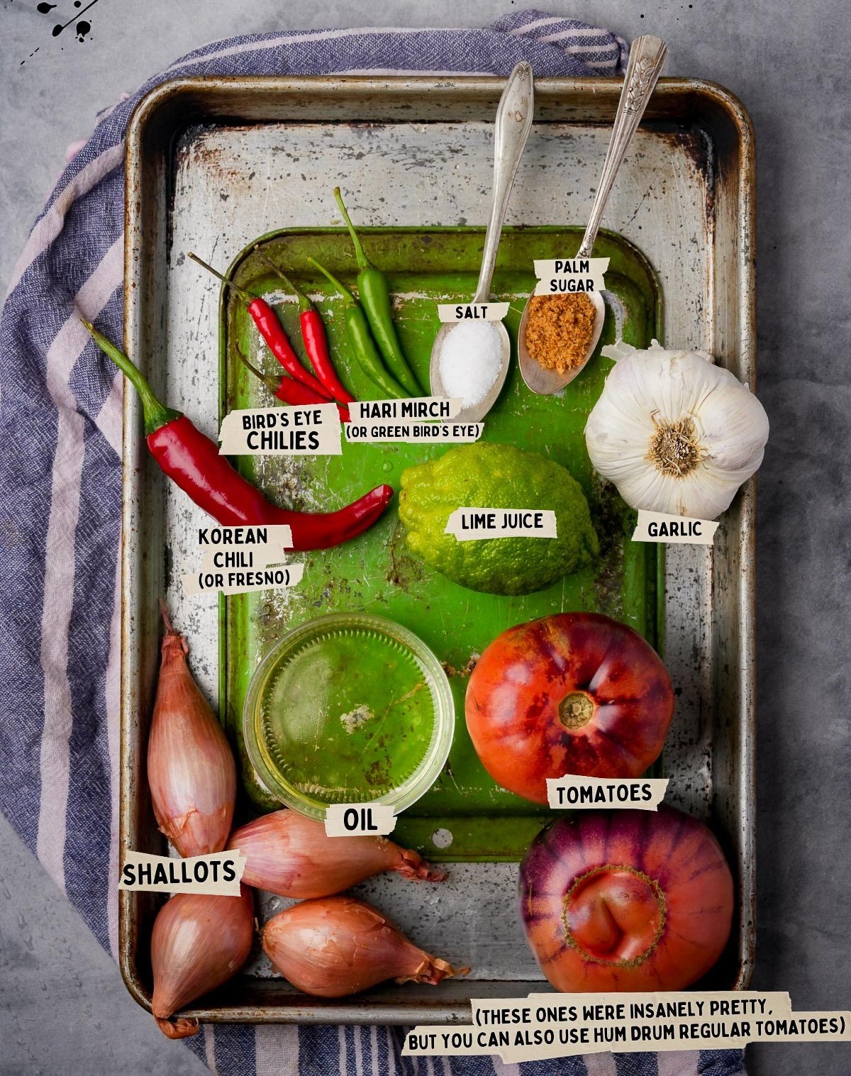 A metal tray with shallots, garlic, tomatoes, chilies, lime juice, salt, oil, and a spoonful of palm sugar—perfect ingredients for sambal dabu dabu.