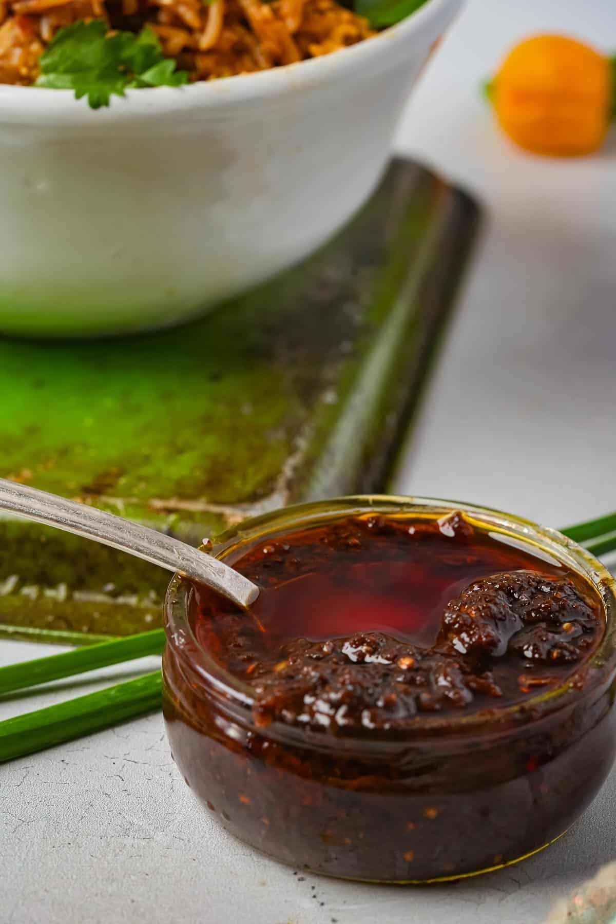 A bowl of rice and a glass jar of nam prik pao.