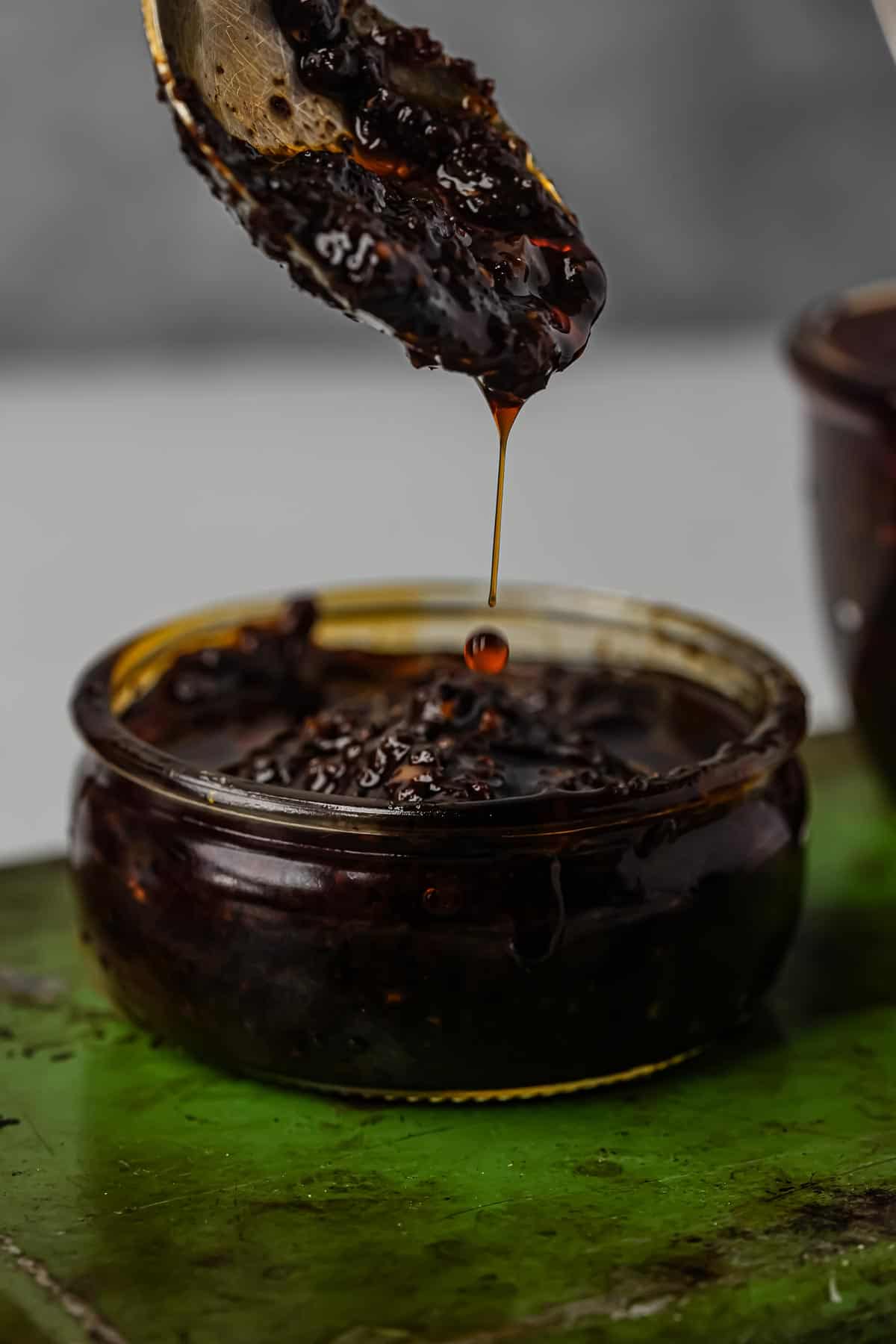 A spoon is being dipped into a bowl of nam prik pao.