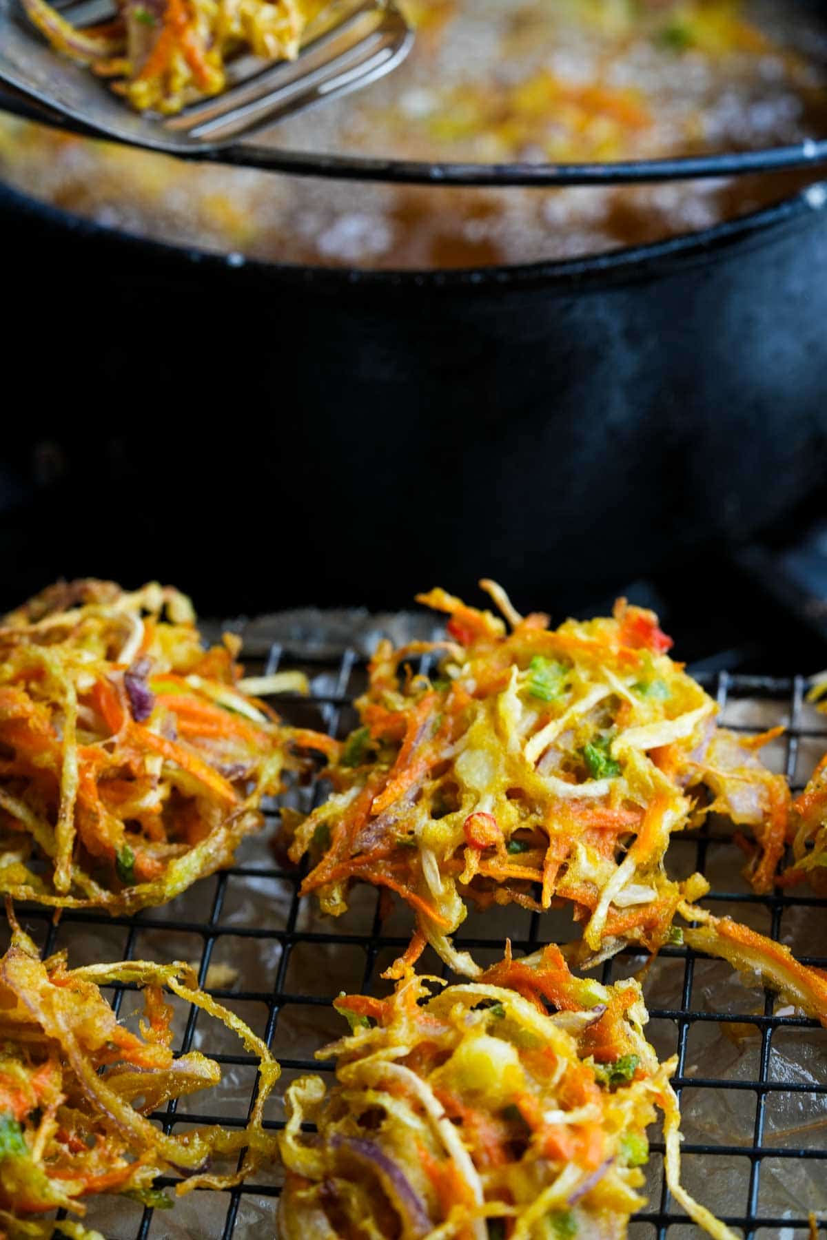 Bakwan sayur draining on a cooling rack.