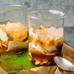 Two glass cups filled with taho on a green tray.