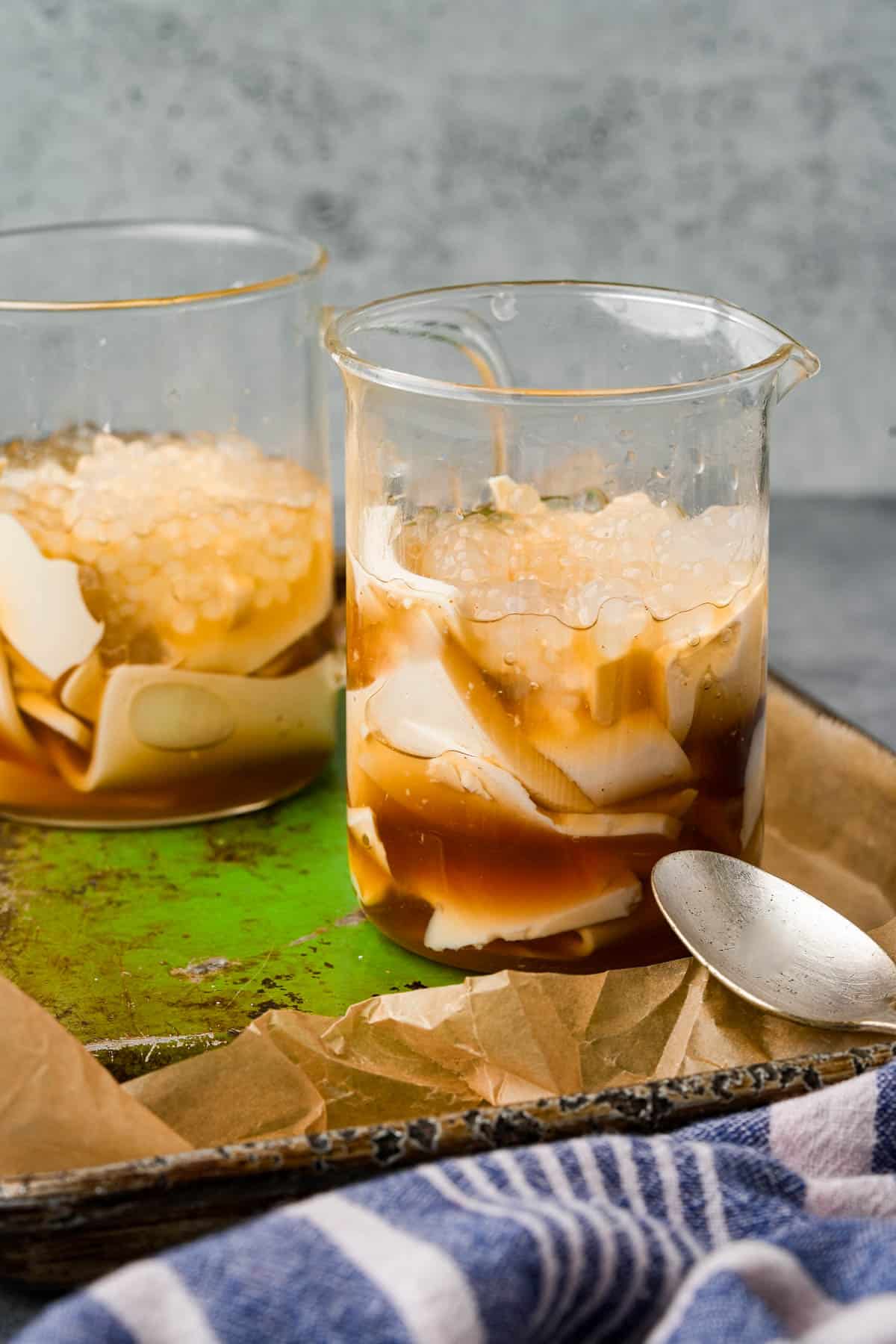 Two glasses with taho in them on a tray.