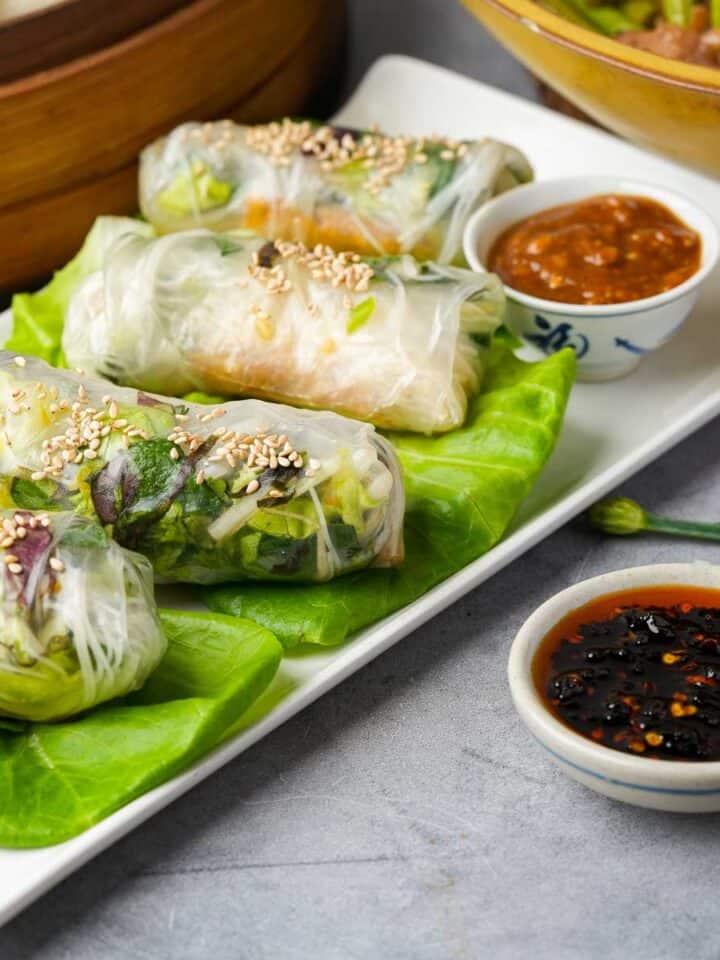 banh trang cuon spring rolls on a plate with dipping sauce.