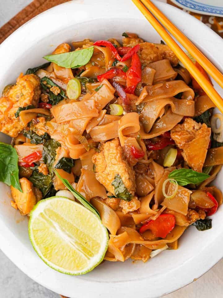 Thai Pad Kee Mao in a white bowl with chopsticks.