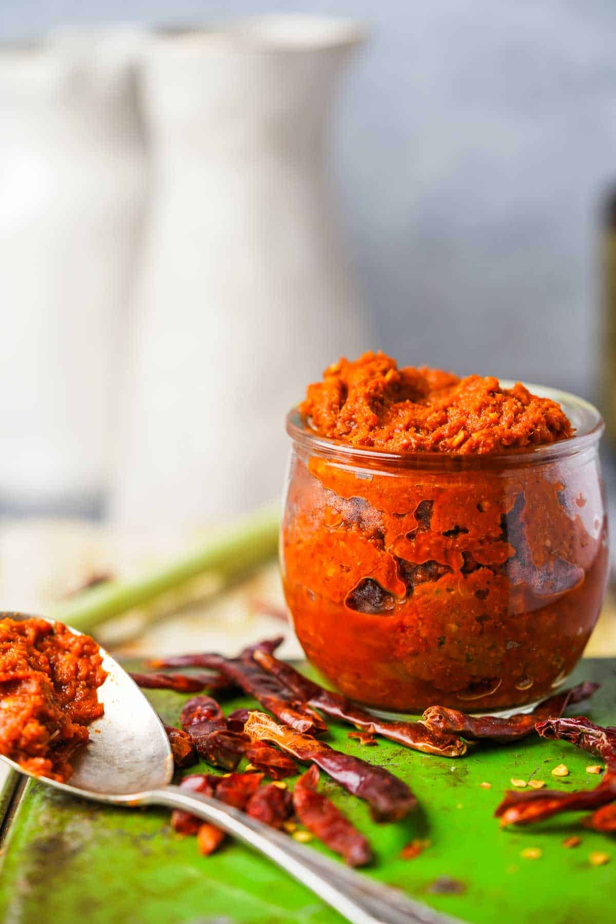 A bowl of red chili curry paste with a spoon.