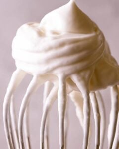 A close up of whipped cream on a whisk.
