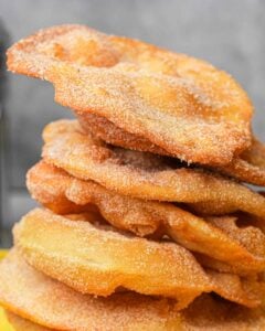 A stack of fried bunuelos on a yellow napkin.