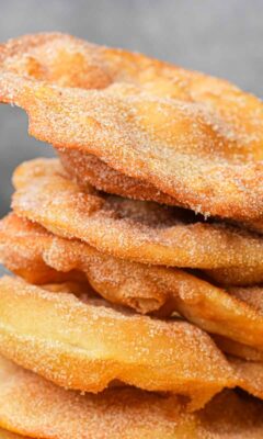 A stack of fried bunuelos on a yellow napkin.
