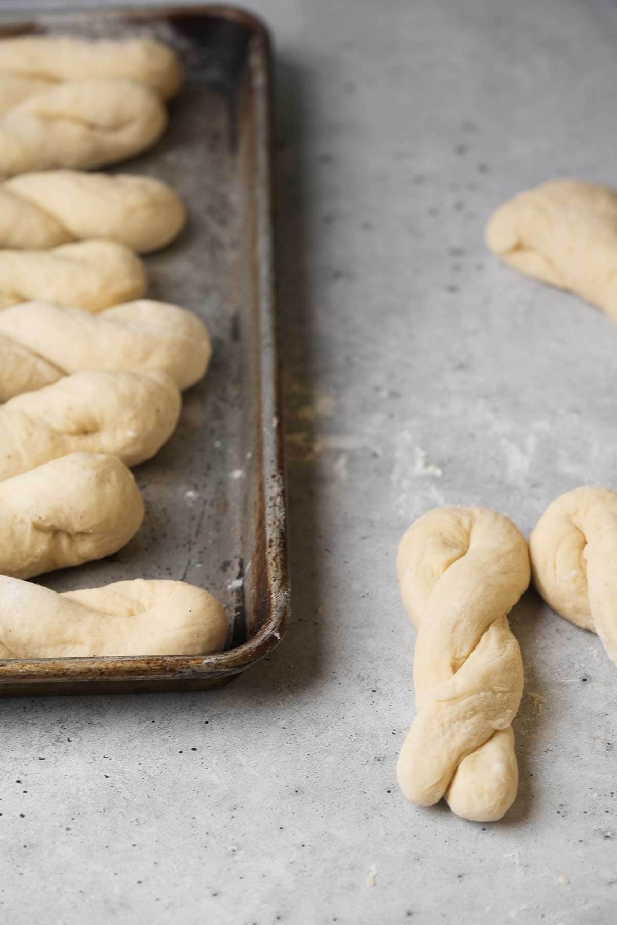 A baking sheet with braided twisted donuts on it.