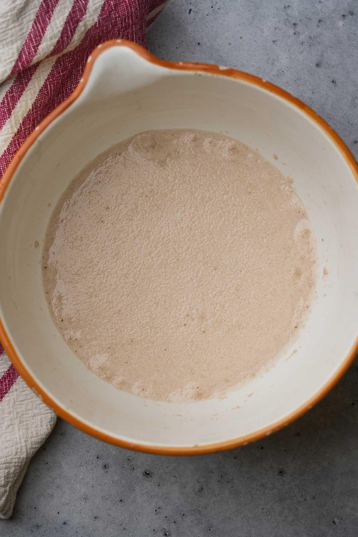 A white bowl with a bloomed yeast in it.