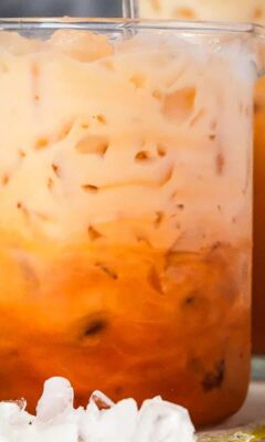A cup of iced Thai tea with a straw.
