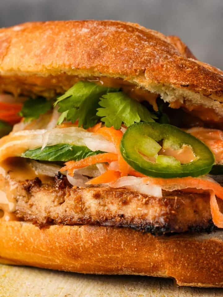 A vietnamese vegan banh mi sandwich on a cutting board.