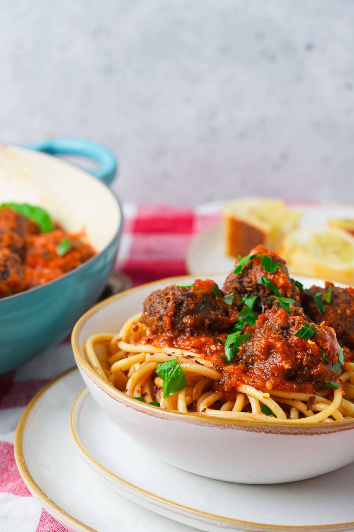 A bowl of spaghetti with vegan meatballs and sauce.