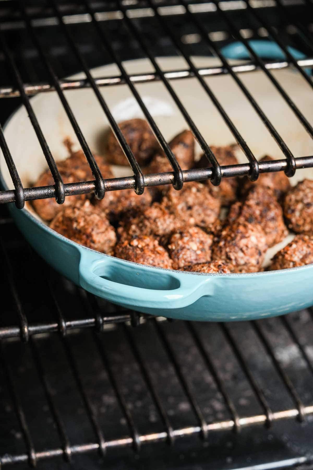 Vegan meatballs in a blue pan on an oven rack.