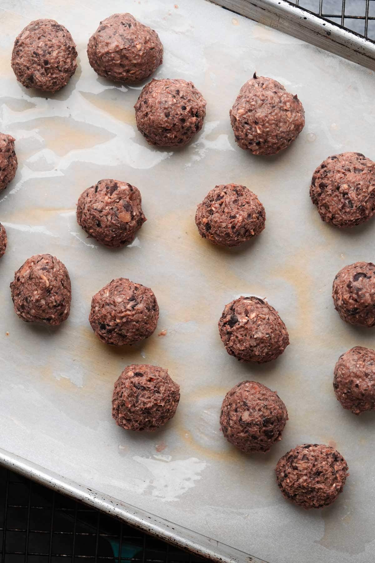 Vegan meatballs on a baking sheet about to be cooked.