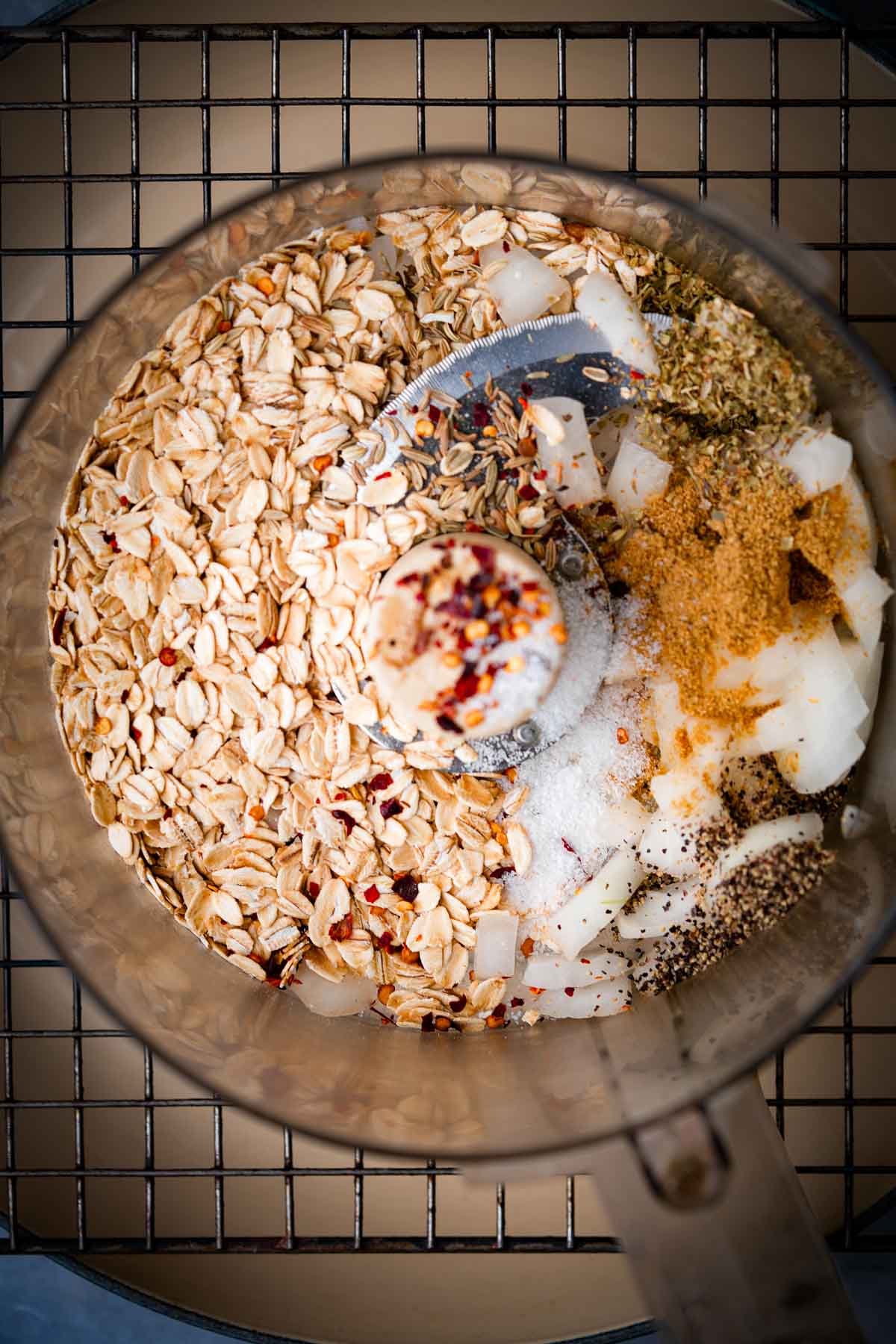 A food processor filled with oats, onions, and other ingredients.