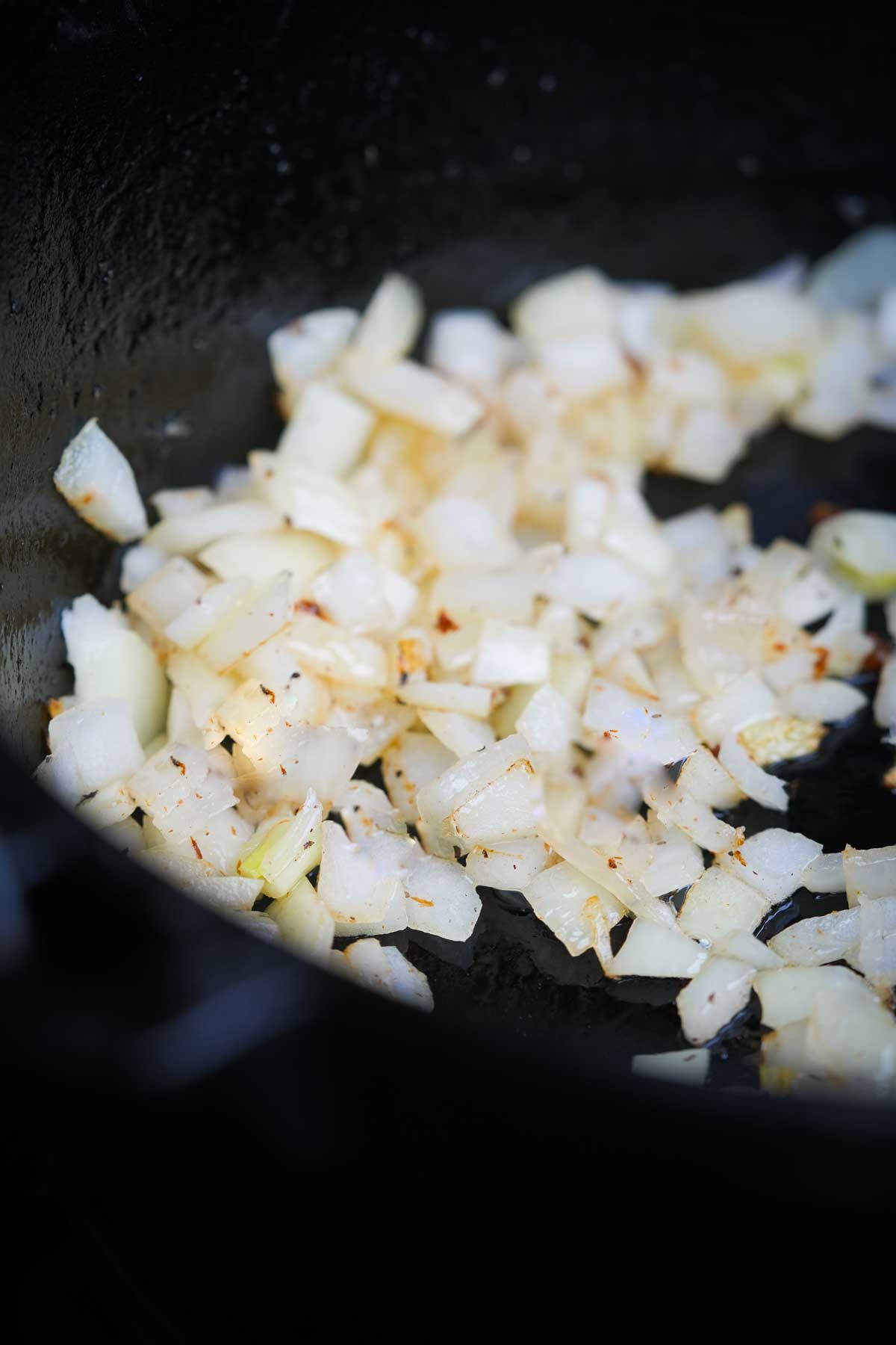 Onions are being cooked in a frying pan.