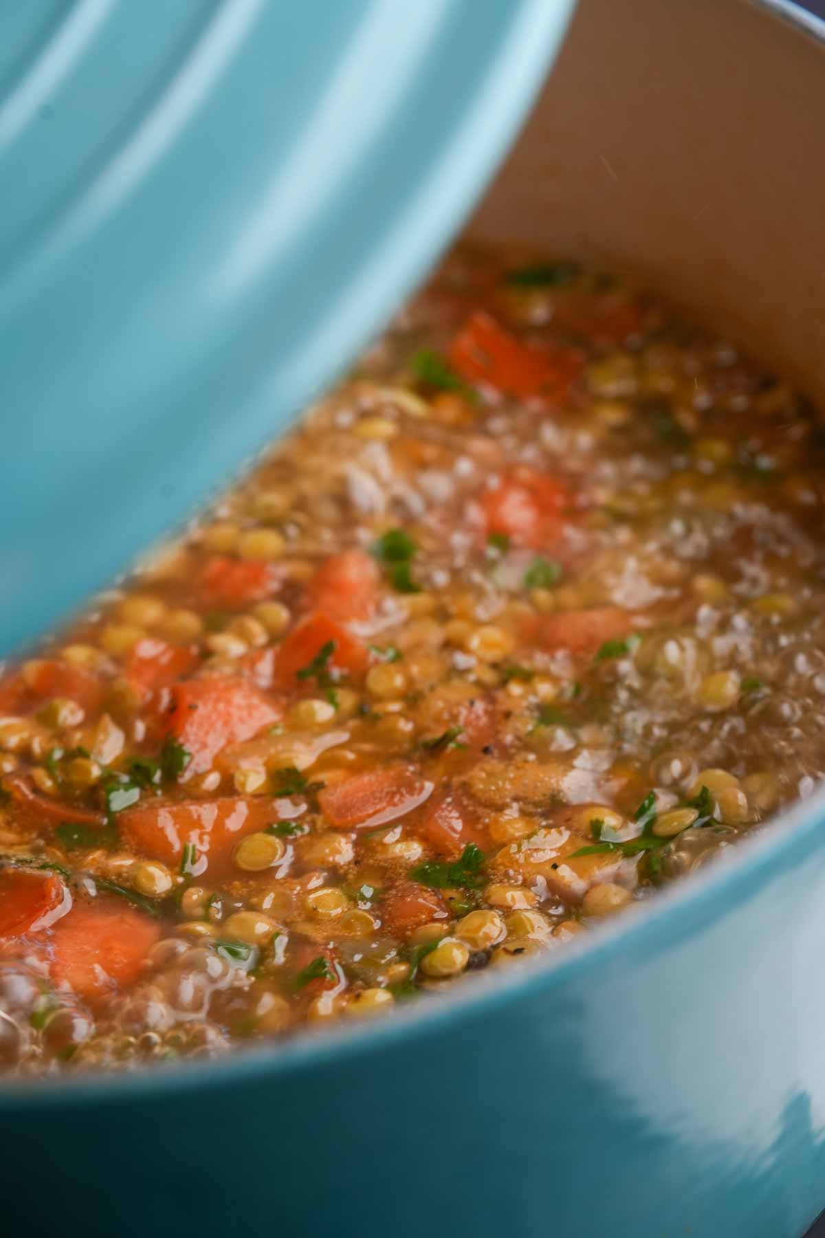 Mexican lentil soup in a blue pot on top of a stove.