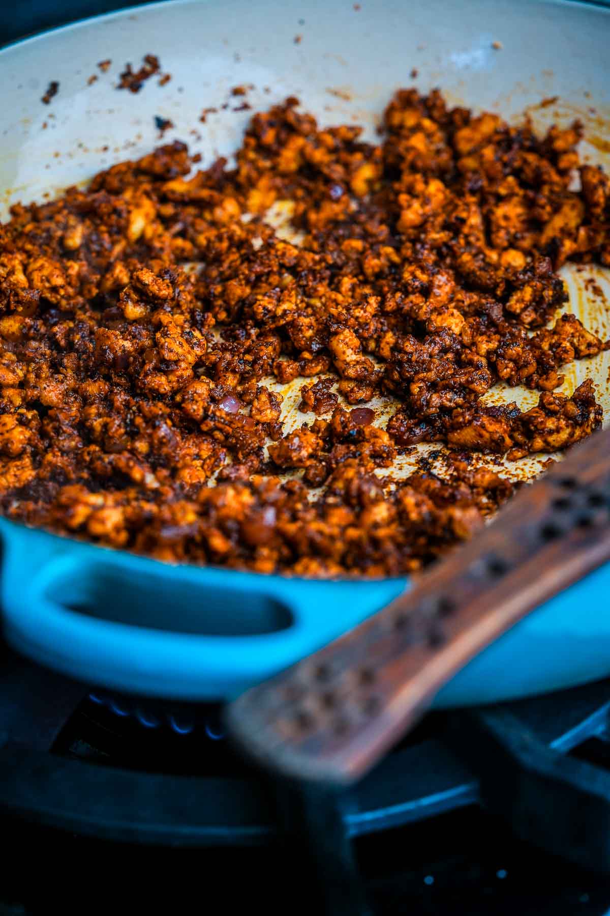 A pan with vegan chorizo in it on a stove top.