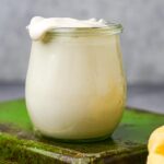 A jar of vegan mascarpone on a green tray.