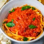 A bowl of fettuccine pasta topped with Vegan Marinara Sauce and fresh herbs.