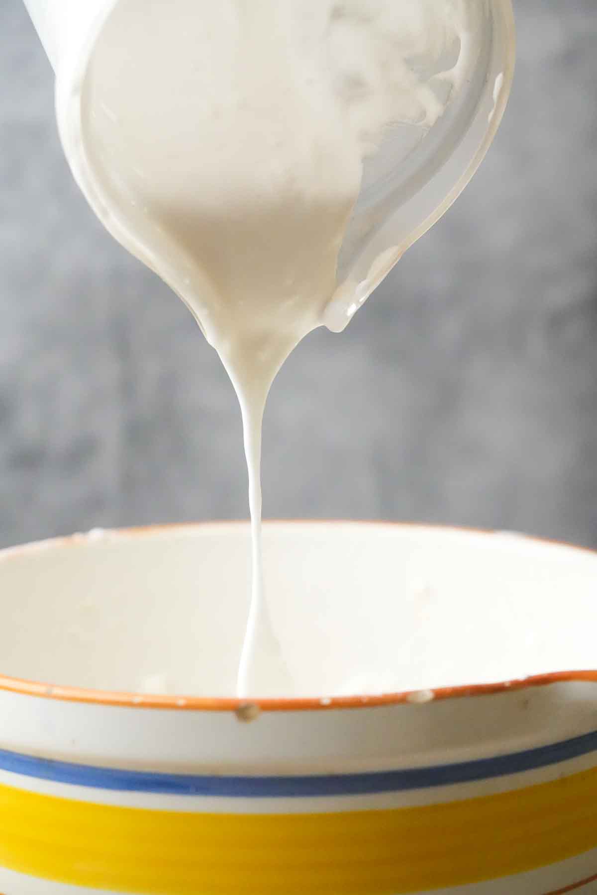 Pouring whipped aquafaba into a bowl.