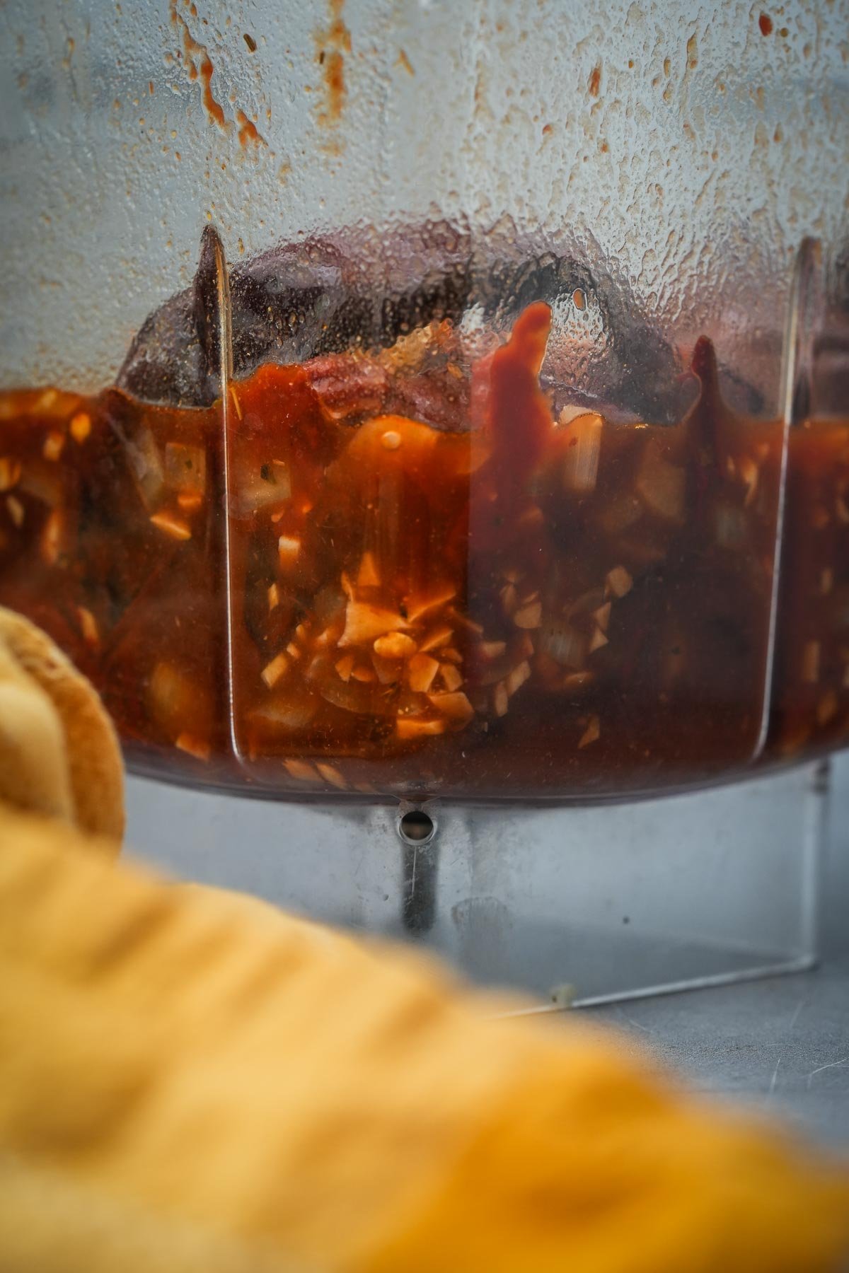 Chili sauce in a clear blender pitcher with condensation, visible drips and chunks of ingredients.