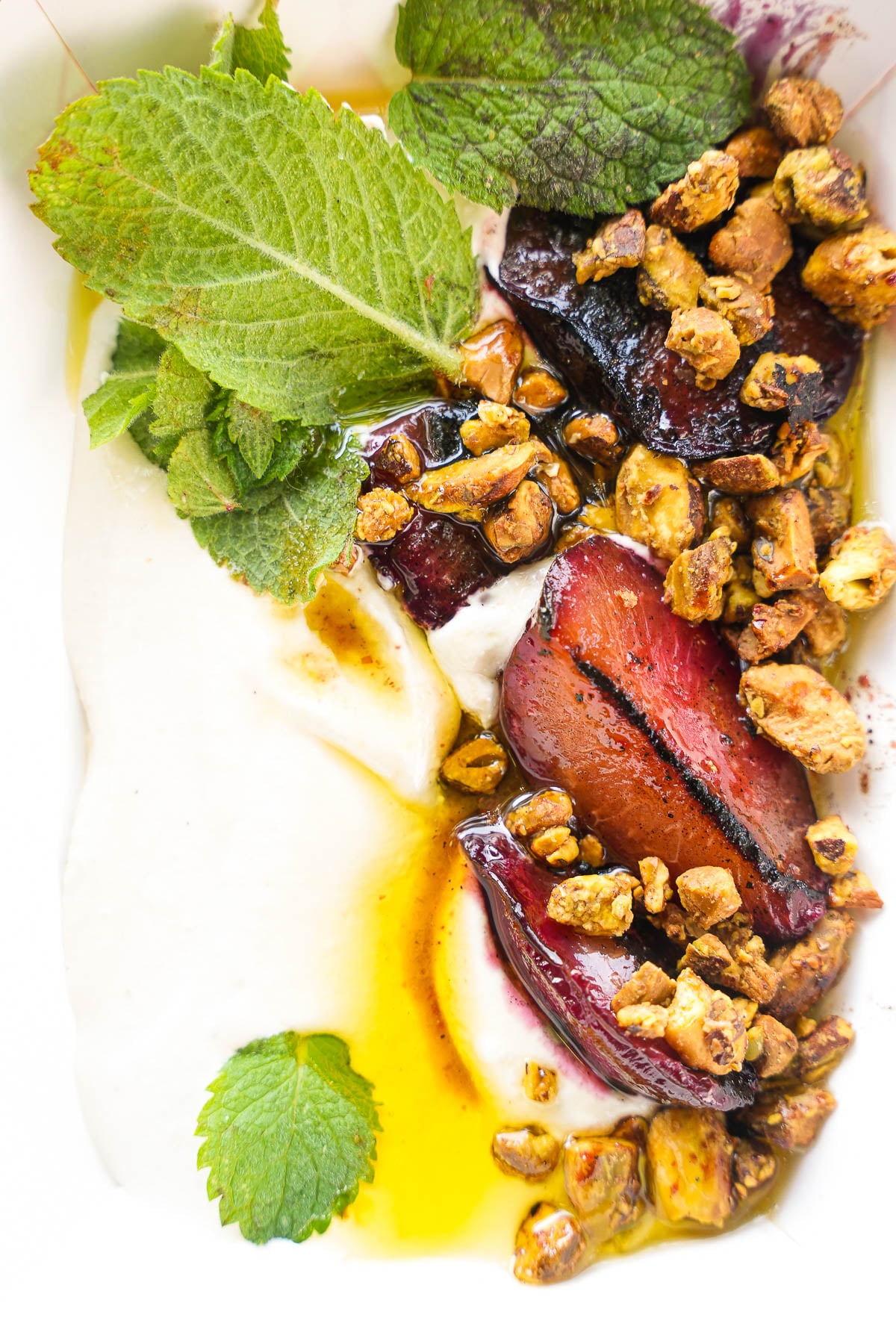 Roasted plums with parsley, almond labneh, and smoked spiced walnuts