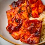 A bowl with spicy Korean braised tofu, rice, and kimchi.