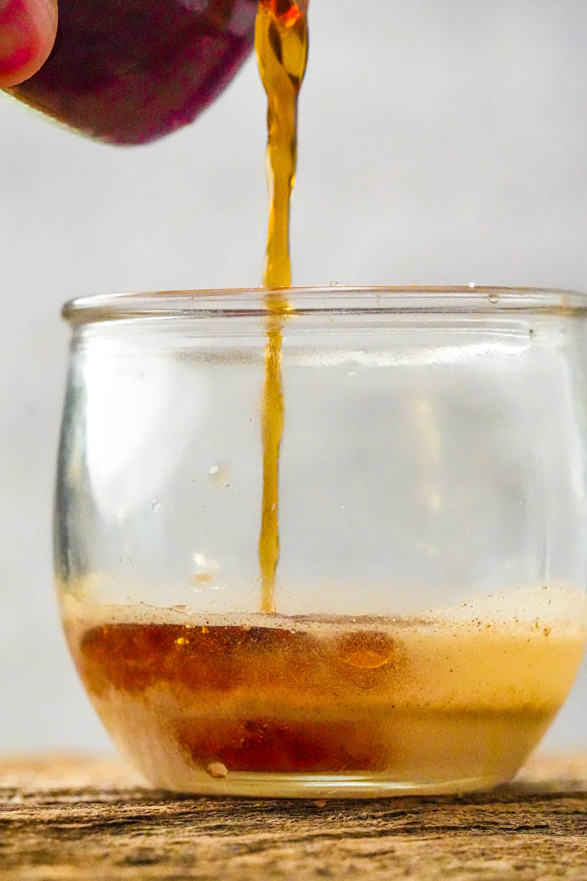 A dressing for ensaladang pipino is being mixed together in a glass.