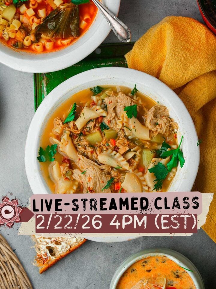 A bowl of hearty soup with vegetables and herbs sits on a gray table among other soup bowls. Text overlay reads: LIVE-STREAMED CLASS 2/22/26 4PM (EST).