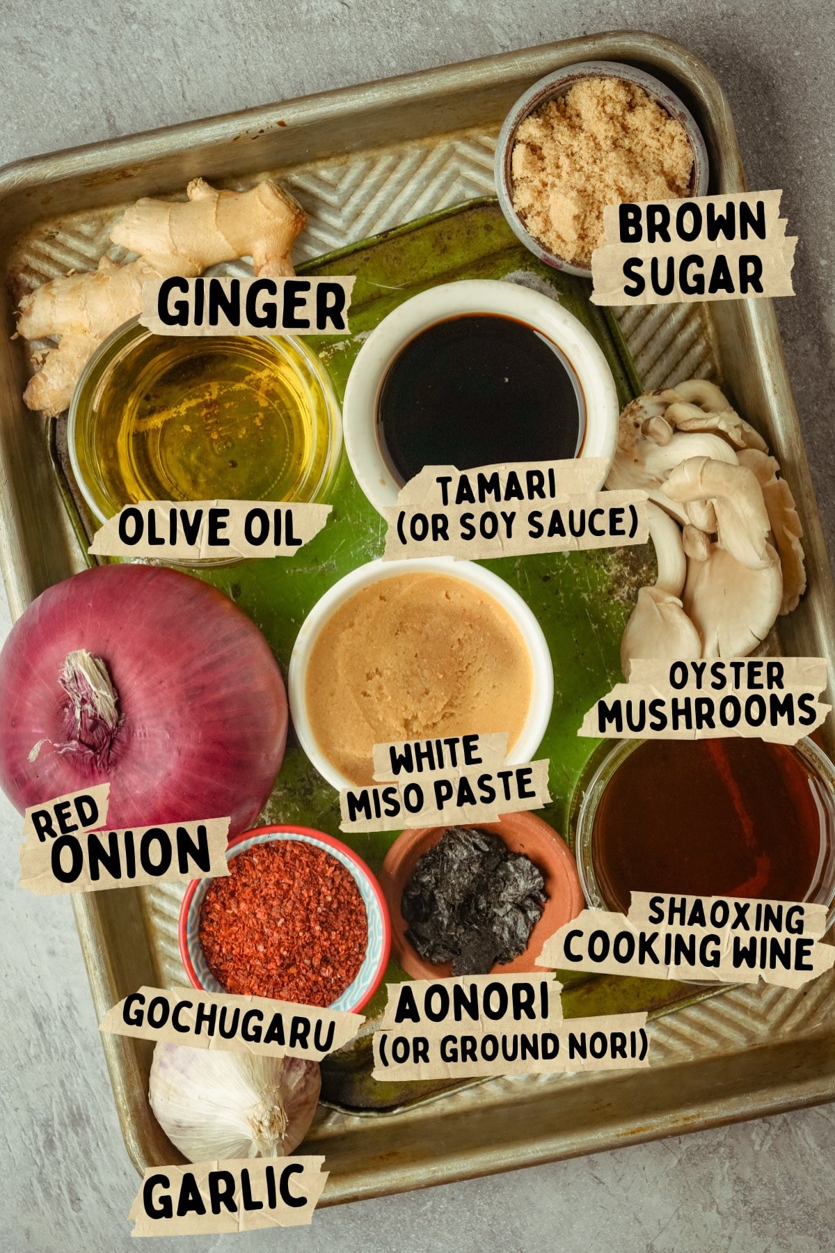 A tray holds labeled ingredients for a vegan shrimp paste recipe: ginger, brown sugar, olive oil, tamari (or soy sauce), oyster mushrooms, white miso paste, red onion, gochugaru, aonori (or ground nori), garlic, and Shaoxing cooking wine.