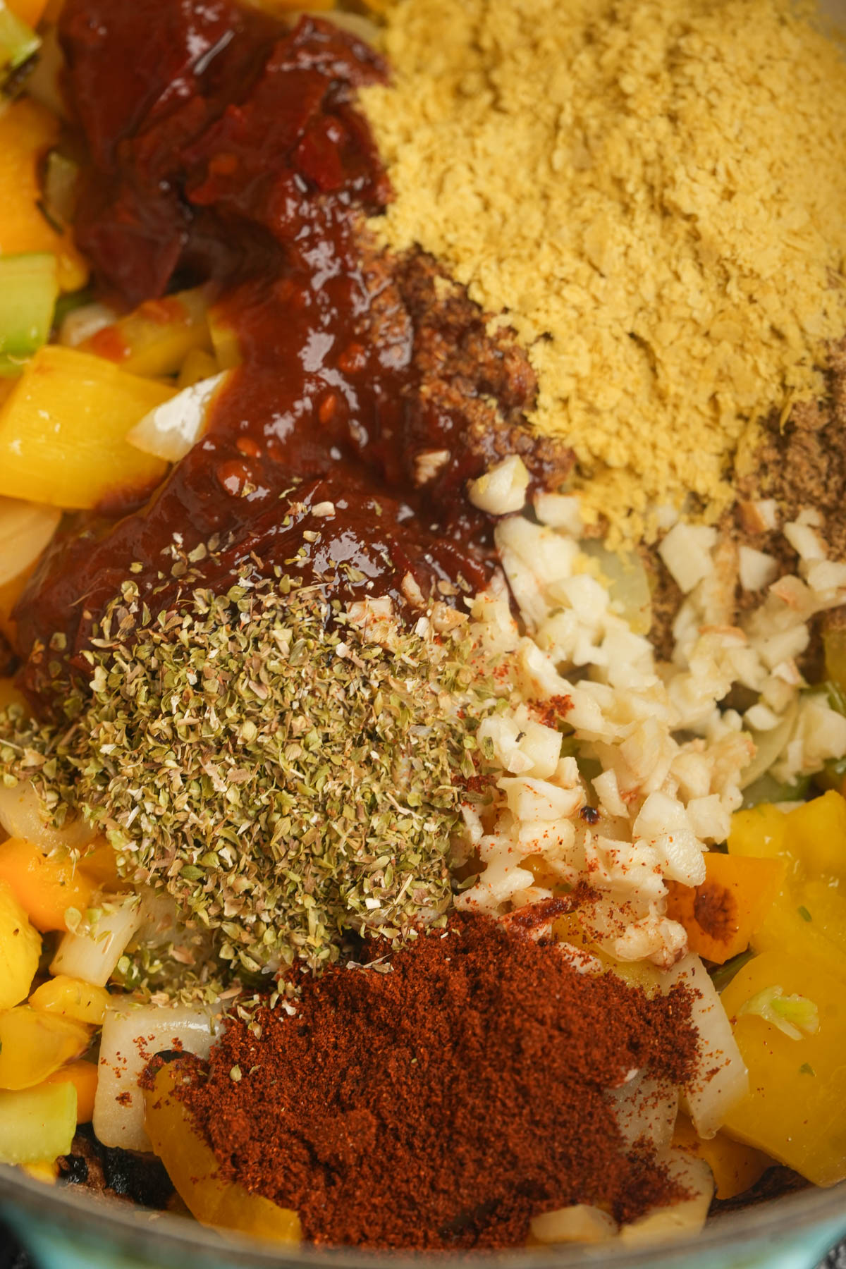 Chipotle peppers, oregano, garlic, and paprika added to sauteeing peppers, onion, and celery.