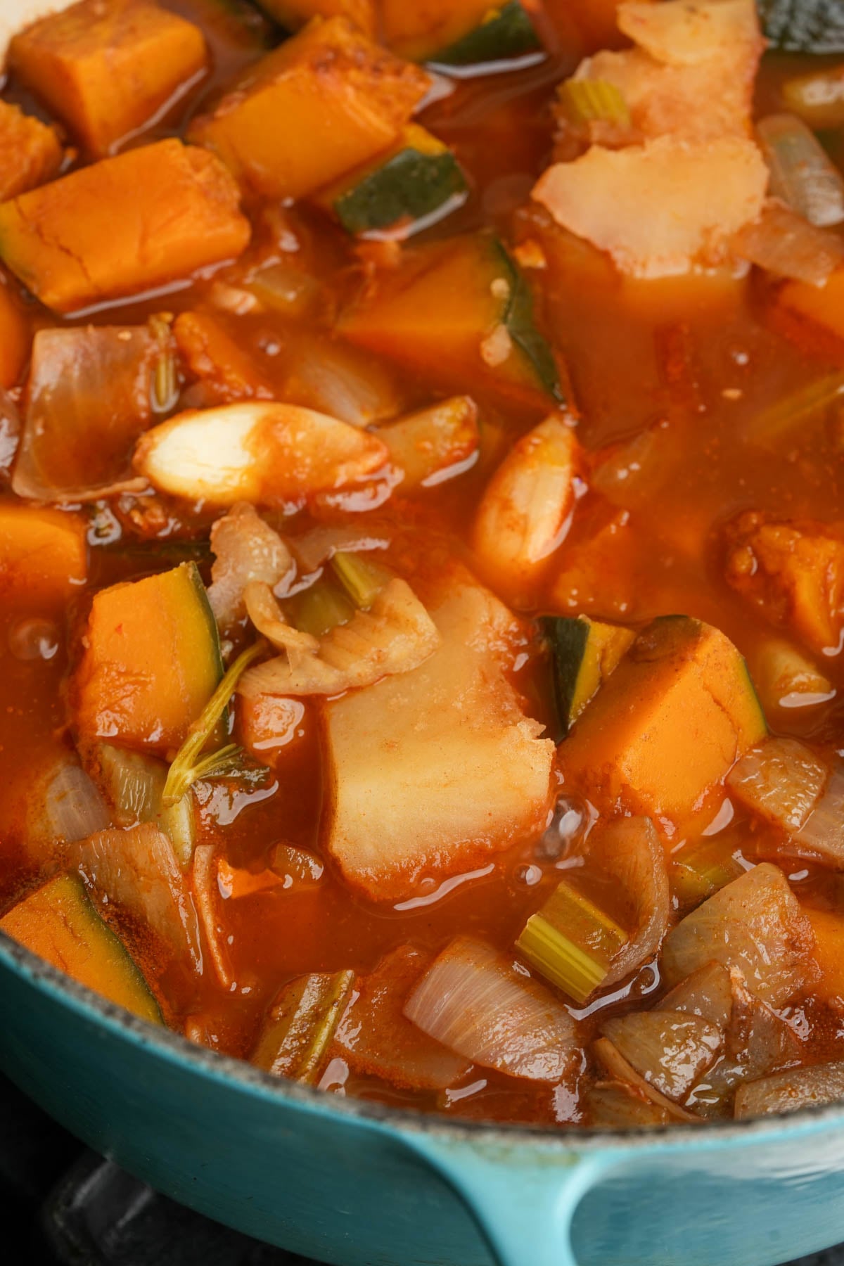 A gochujang kabocha squash soup simmering in a blue pot.