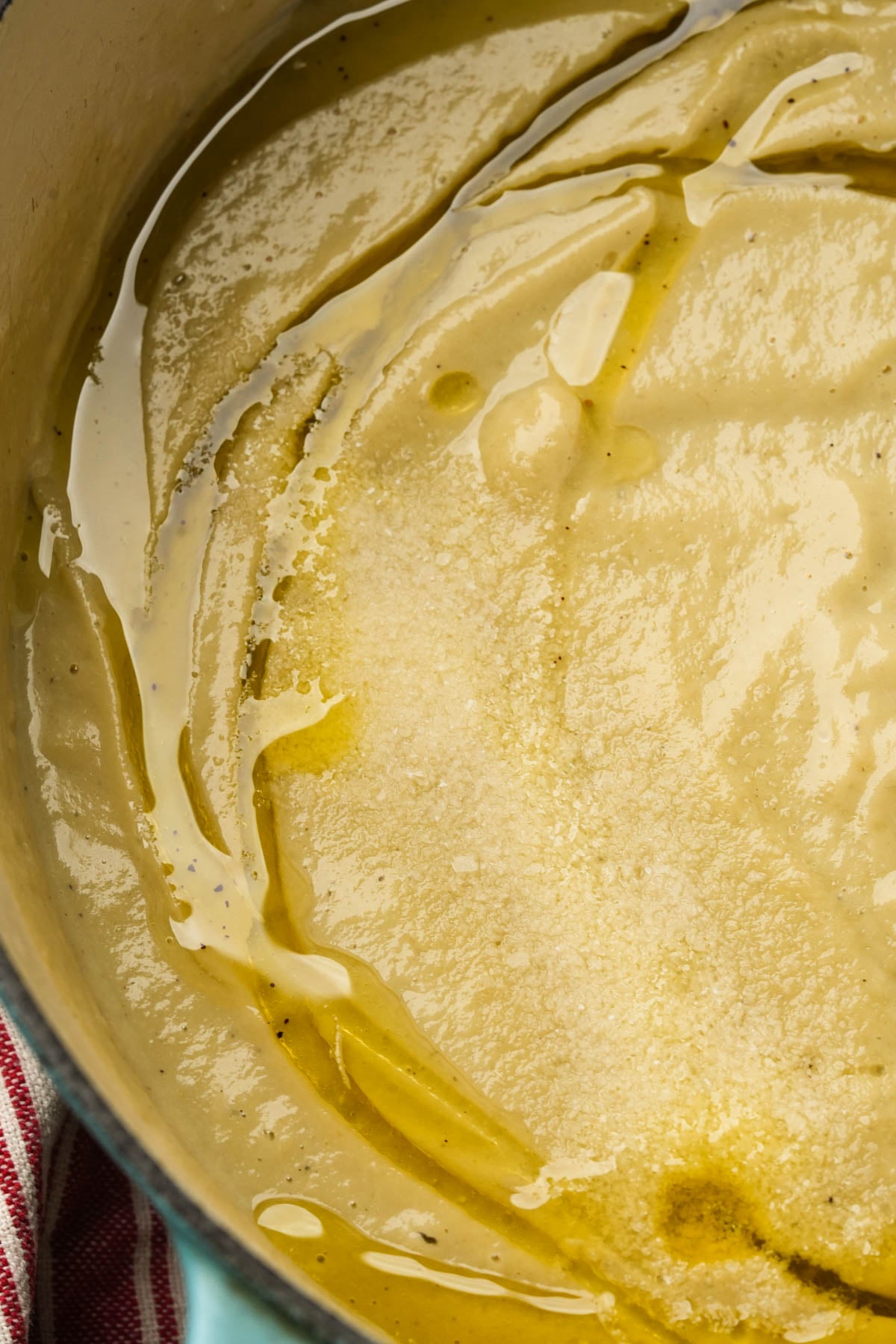 Close-up of truffle oil swirling over a pot of truffle cauliflower soup.