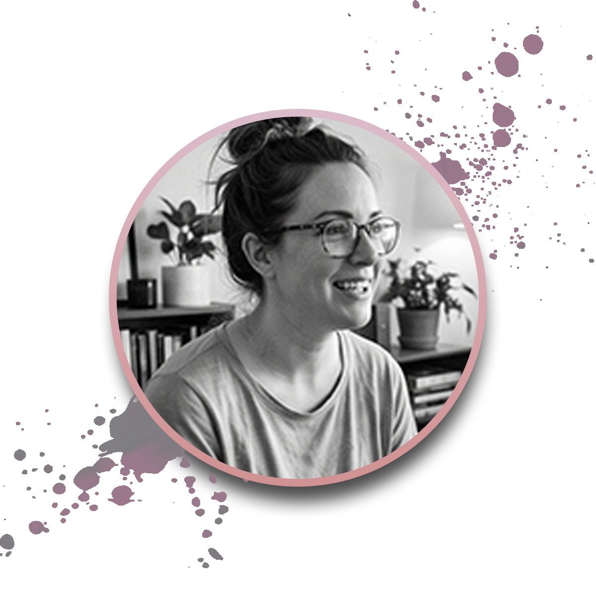 Black and white photo of a smiling woman with glasses and hair in a bun, sitting indoors with plants and books behind her. The image is framed by a pink circle with decorative paint splatters on a white background.
