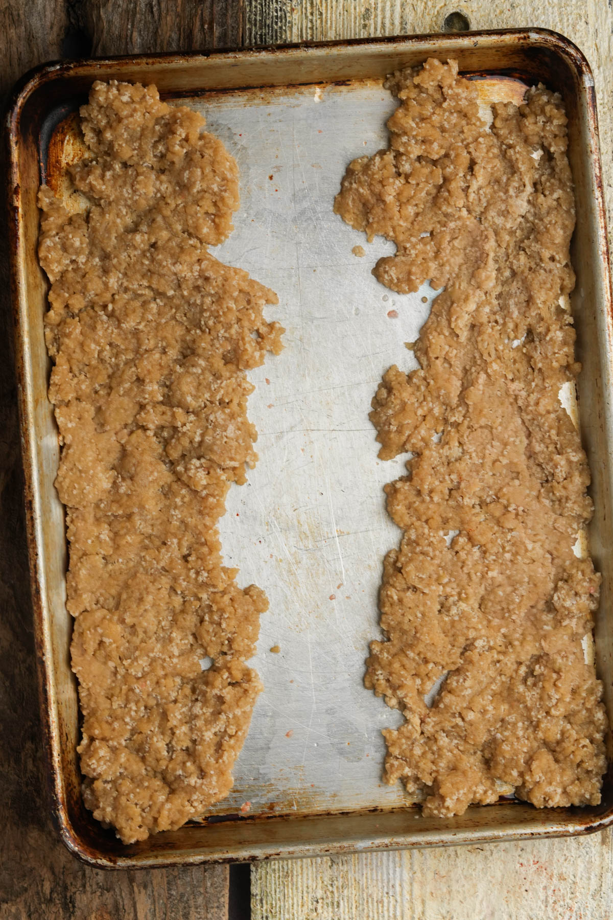 Fat dough pressed into 2 long rectangles on a baking sheet for vegan BBQ ribs.