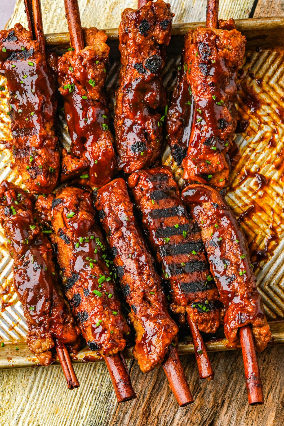 Grilled vegan BBQ ribs brushed with more sauce and sprinkled with minced chives.